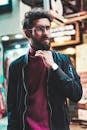 Portrait of a stylish man with glasses in an urban street setting, showcasing modern fashion.